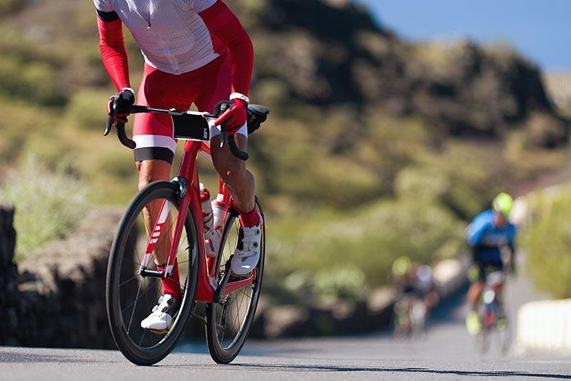 two men riding bicycles on a mountain road 