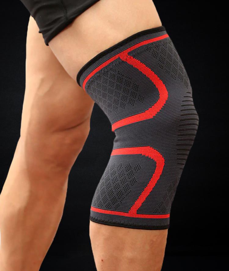 Man wearing red and gray Spartan Fit sports and fitness compression knee sleeve before workout.